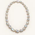 Long white baroque pearl necklace on ivory background
