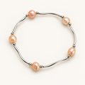 Peach freshwater pearl and silver-tone bar stretch bracelet on ivory background