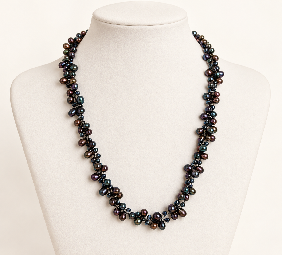 Cultured freshwater peacock pearl and crystal necklace on ivory bust